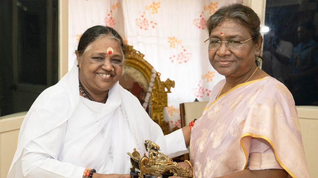 The President smiles as she sits beside Amma.
