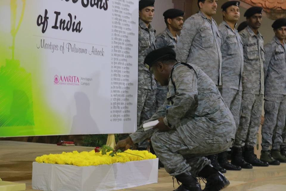 a soldier places a rose at the base of the banner