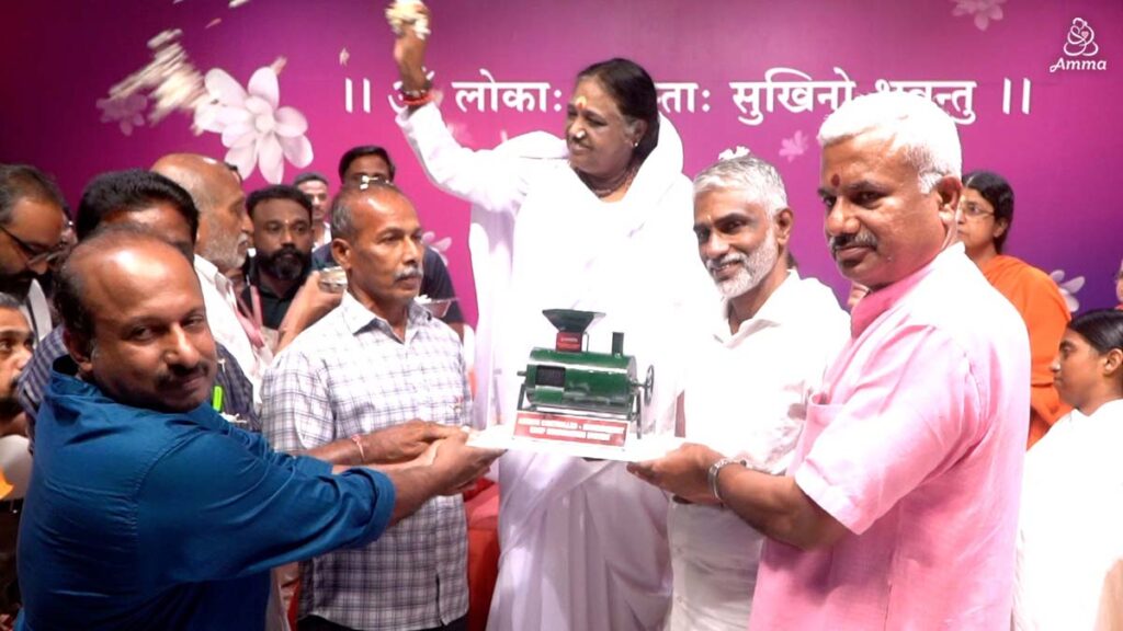 Amma showers petals on a group of farmers