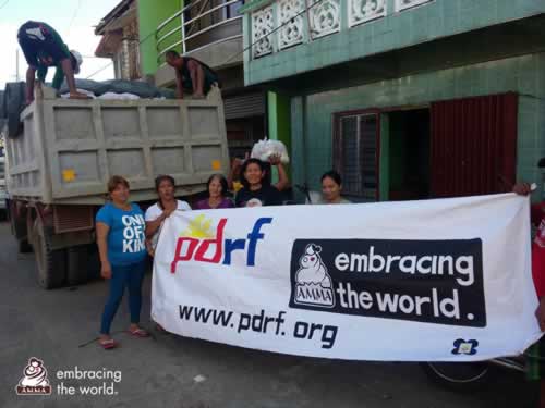 Volunteers stand with an Embracing the World banner