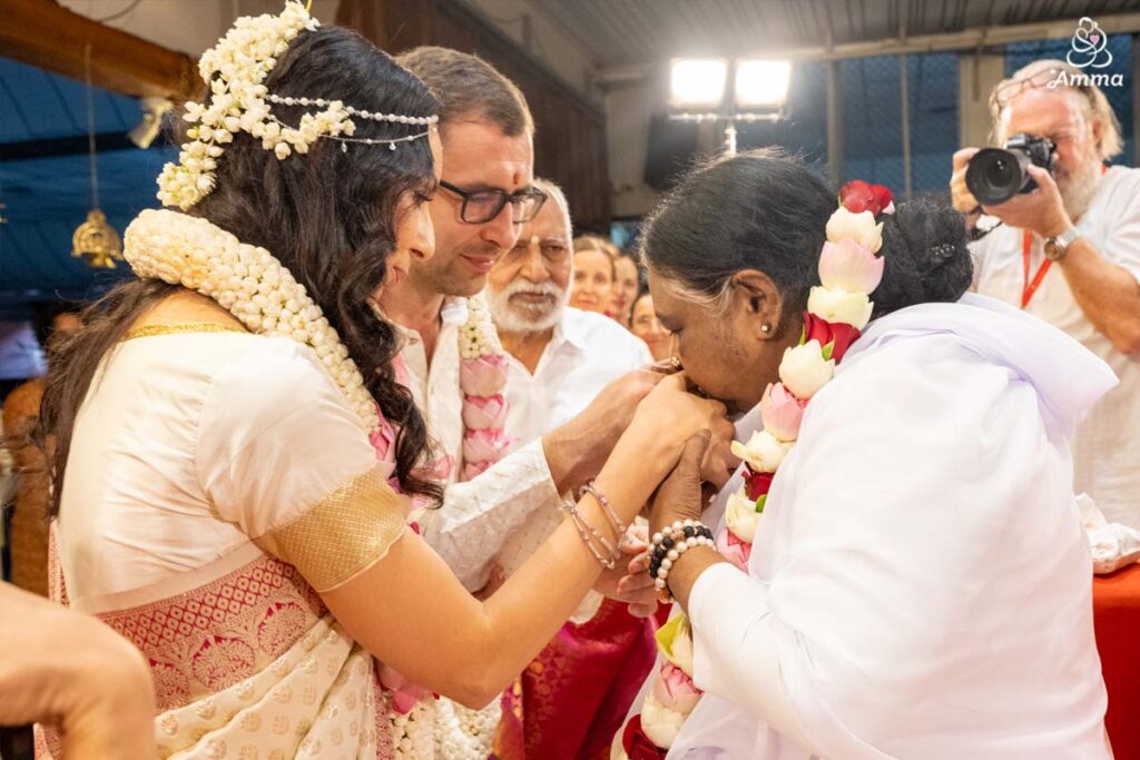 Amma kisses the newlyweds' hands