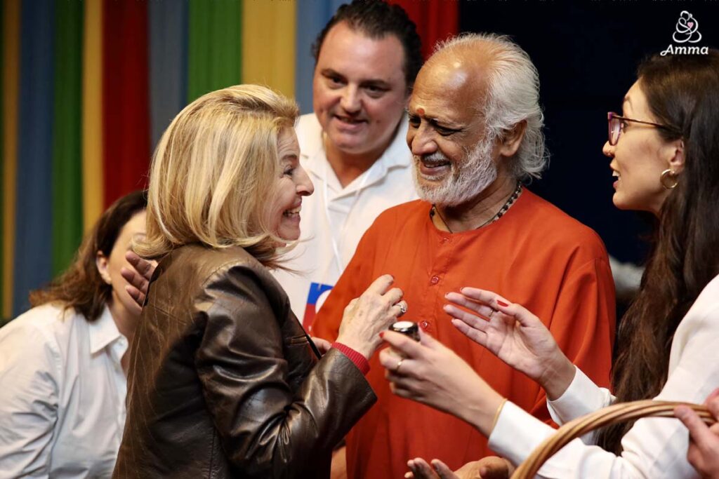 A woman meets a Swami, both smiling