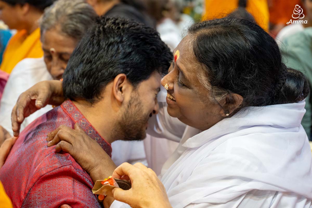 Amma embraces a crying man