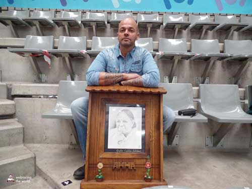 A prisoner sits with a plaque of Amma's photo