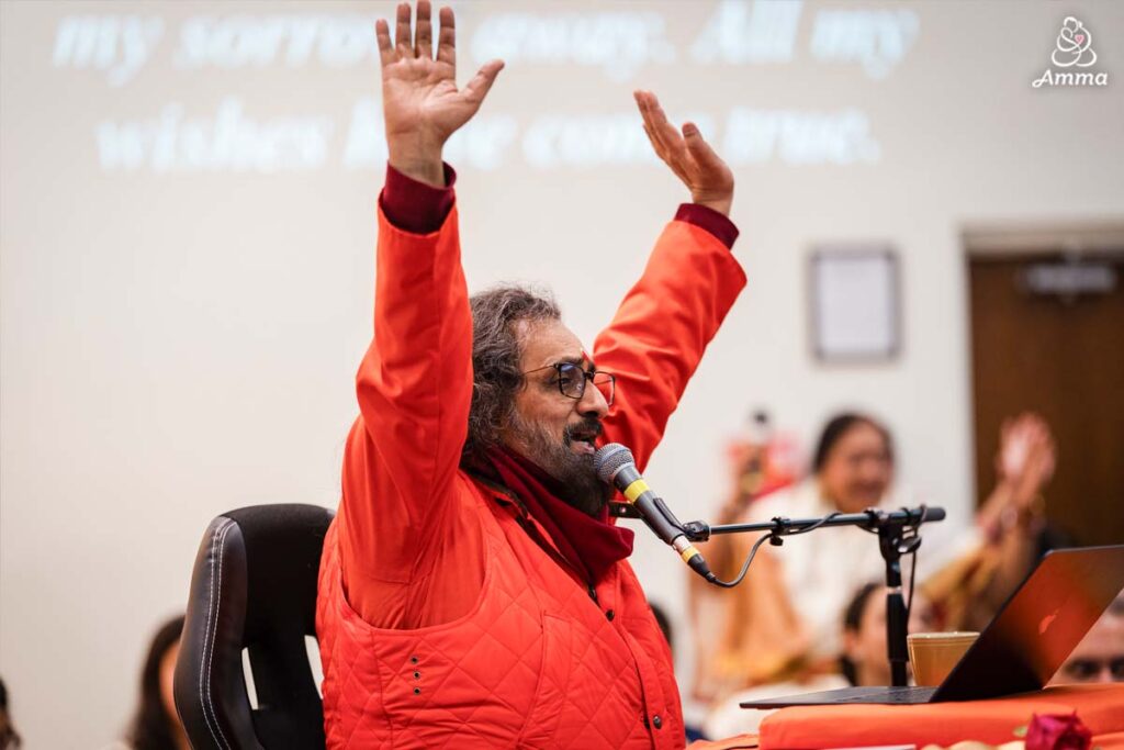 a swami raises his arms with prayers to the Divine Mother