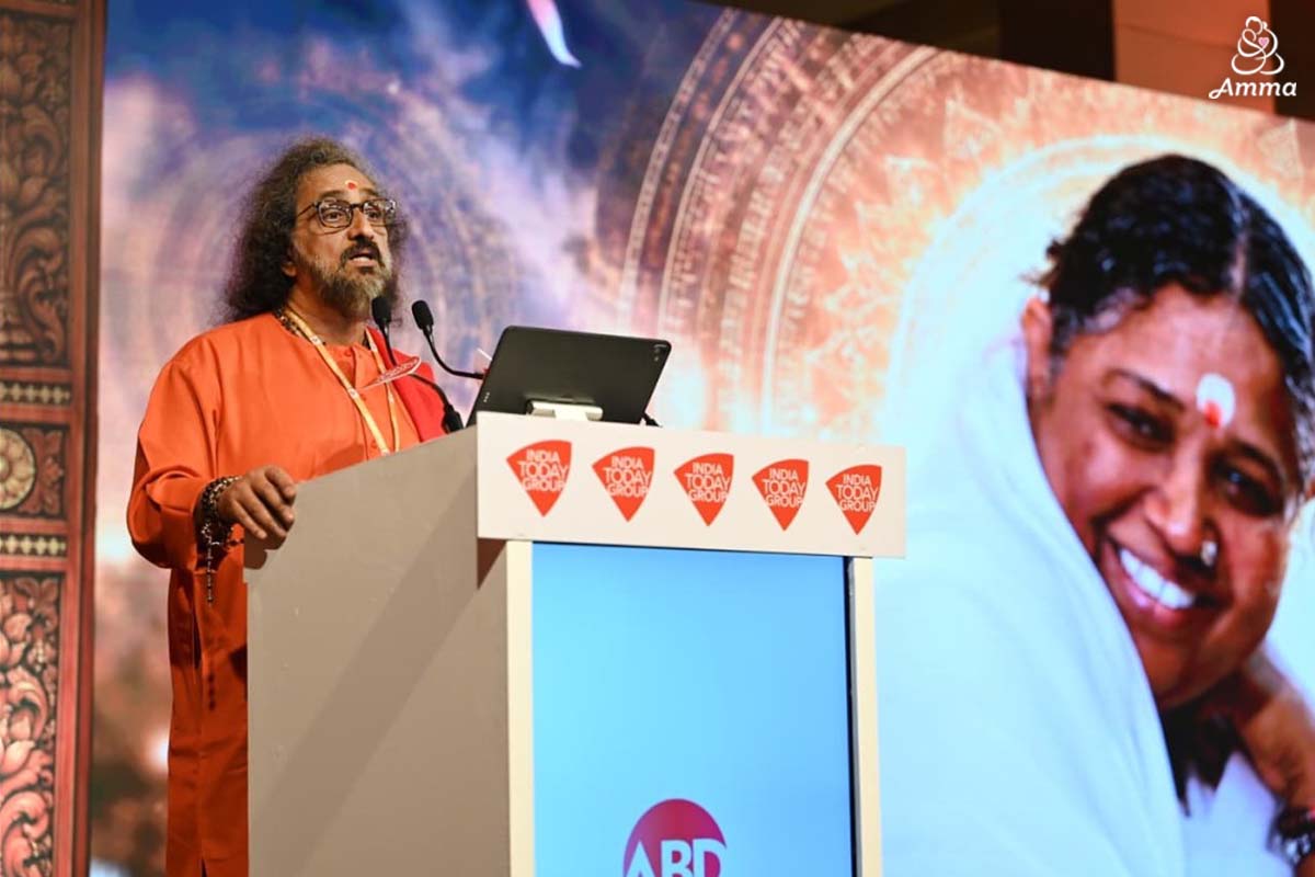 A swami speaks at a microphone