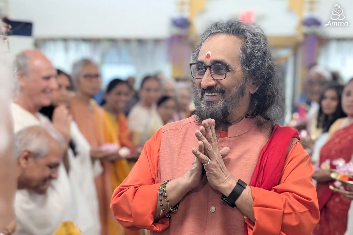 A swami smiles at a gathering of people