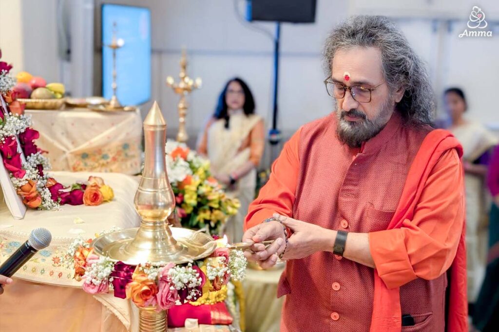 A swami lights an oil lamp
