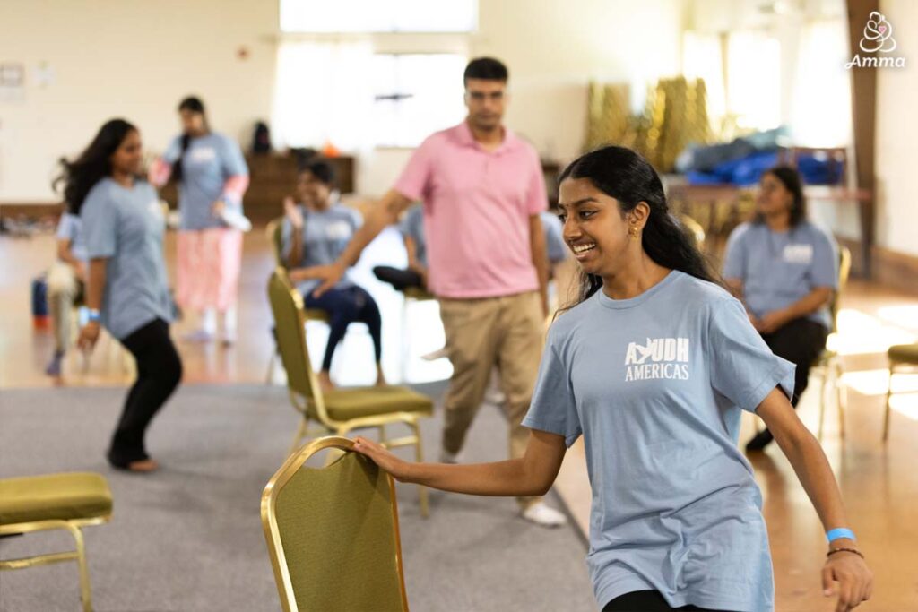 Young people run around chairs