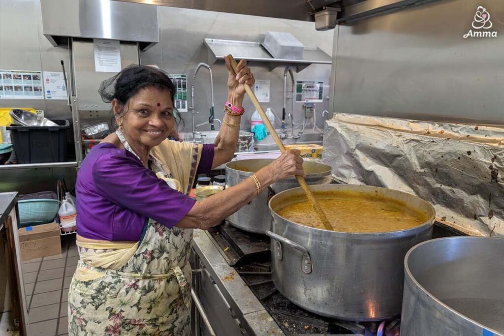 A woman cooks in big pots