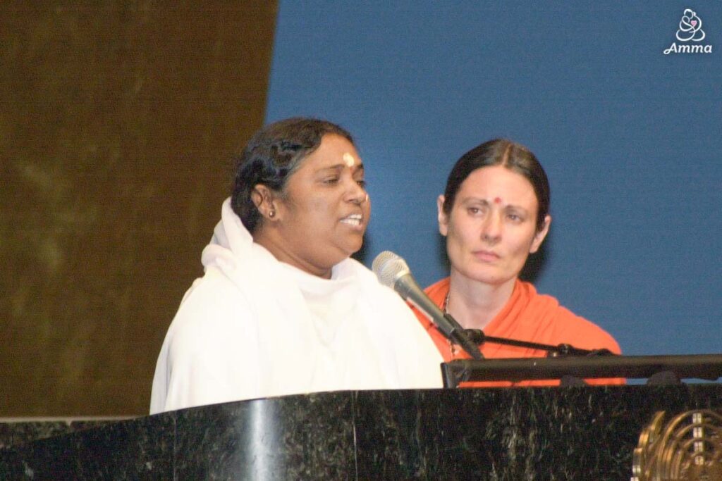 Amma speaking at a microphone