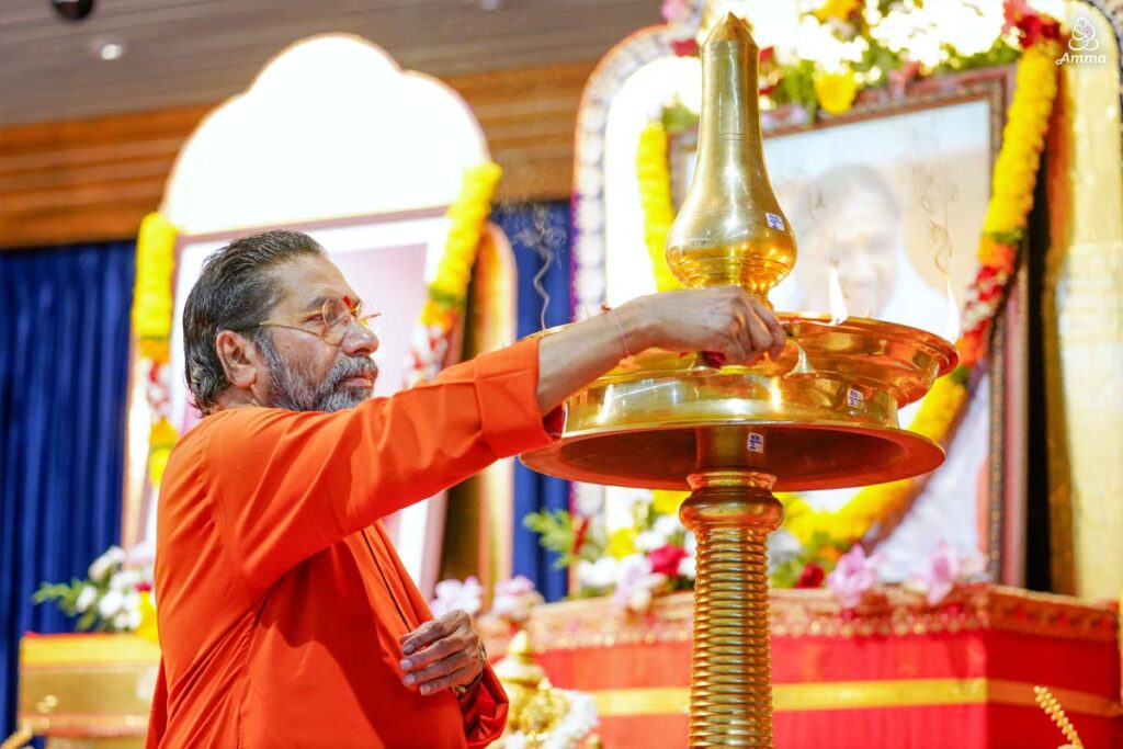 A Swami lights a lamp