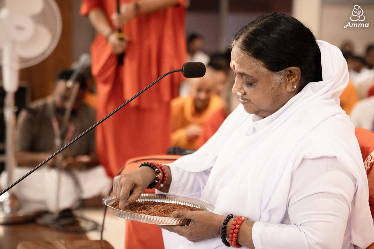 Amma writes in a plate of rice