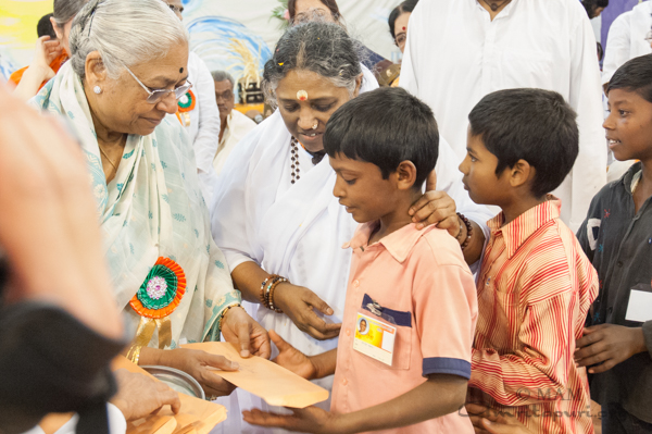 Children receive envelopes from Amma
