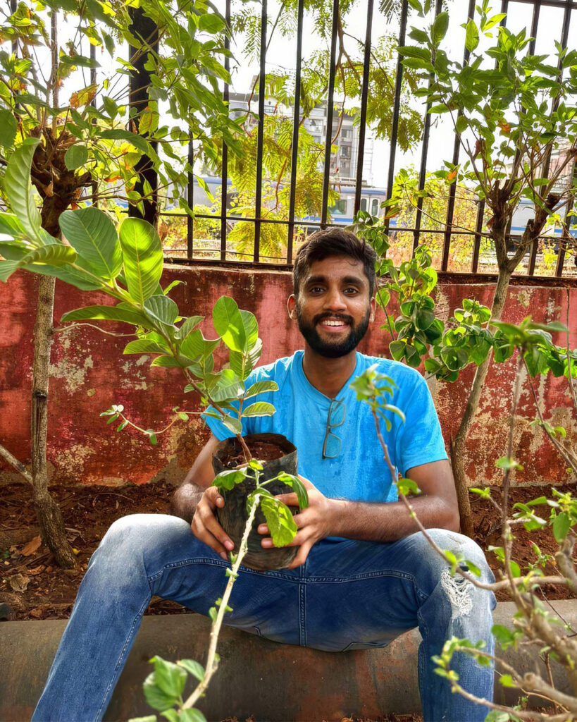 A young man holds a sapling
