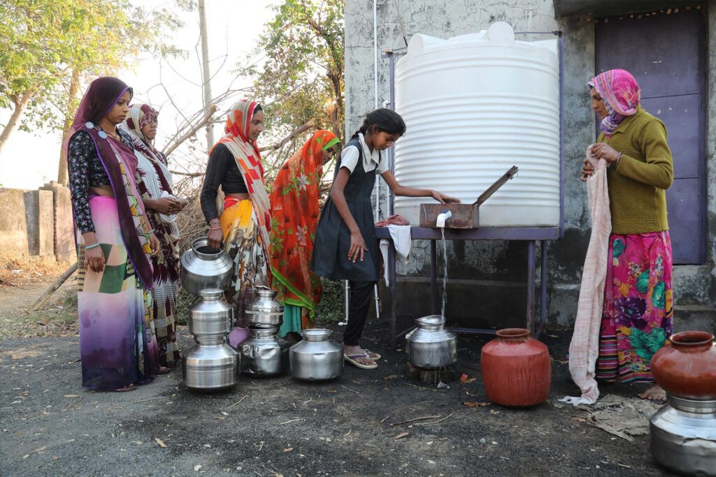 women collecting filtered water